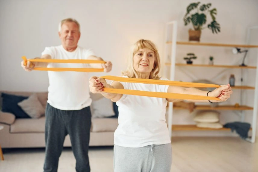 Seniors doing resistance band exercises in garden